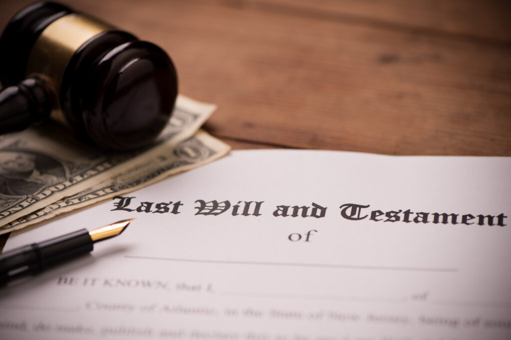Last will and testament form with gavel by Fabio Balbi - A close-up of a “Last Will and Testament” document on a wooden table with a fountain pen, several one-dollar bills, and a judge’s gavel resting nearby.